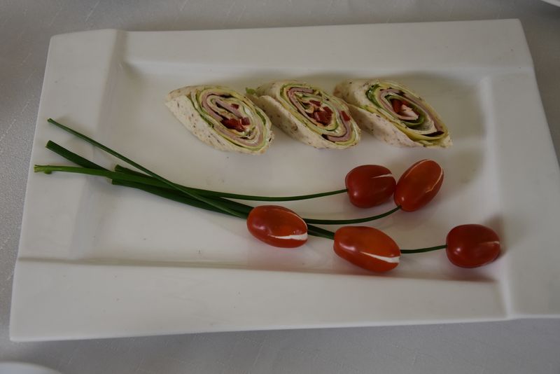 Na talerzu znajduje się dekoracja wykonana przez uczniów technikum gastronomicznego Zespołu Szkół im. Andrzeja Średniawskiego w Myślenicach zawierającą dwa tulipany wykonane z pomidorków koktajlowych wypełnionych białym serkiem twarogowym, na łodydze ze szczypiorku. Obok ułożono trzy kawałki rolady zrobionej z tortilli, szynki, sałaty, papryki oraz sera żółtego